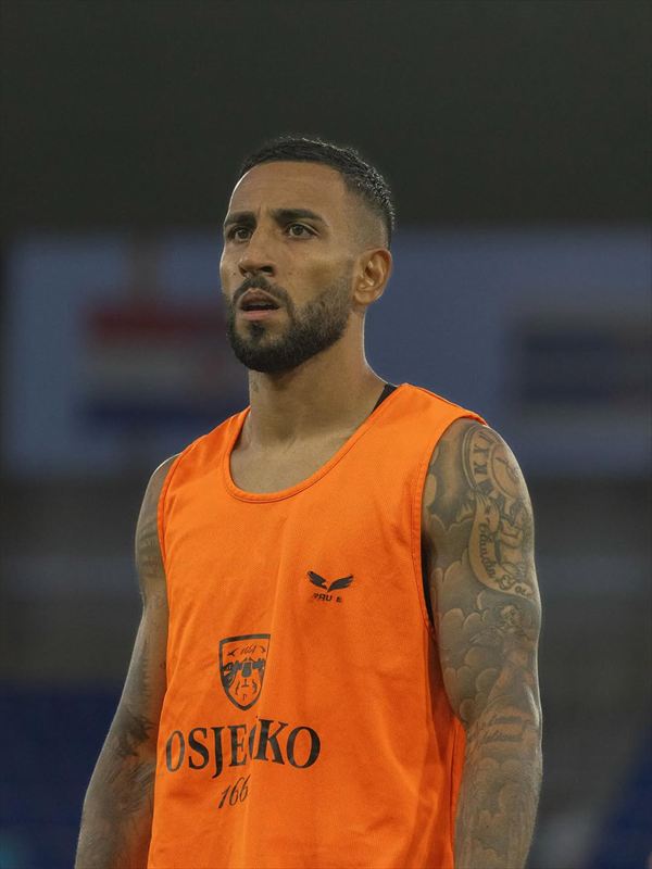 Renan Guedes com o colete laranja de treino do NK Osijek, em campo.